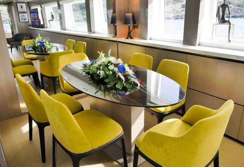  Yacht Photos Pics Luxurious yacht interior with yellow chairs and elegant floral centerpiece, Admiral 85, 2008 model.