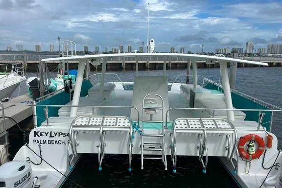 Keylypso Yacht Photos Pics Custom 1998 catamaran docked in Palm Beach, Florida, with spacious deck and seating.