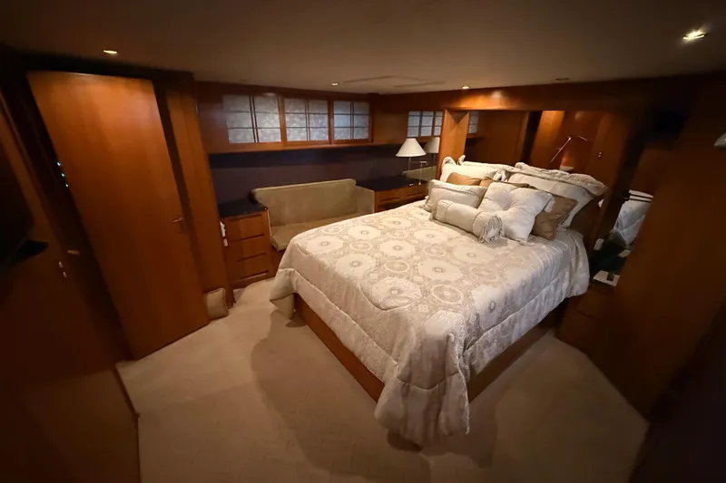 Bonnie Jean Yacht Photos Pics Luxurious bedroom in 1998 Ocean Alexander Pilothouse Model 584 yacht, featuring elegant bedding and warm lighting.