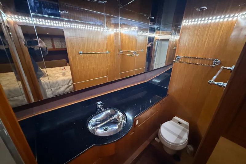 Bonnie Jean Yacht Photos Pics Luxurious bathroom in 1998 Ocean Alexander Pilothouse Model 584 yacht, featuring wood paneling and modern fixtures.