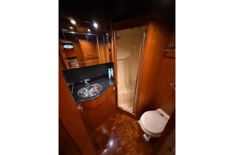 Bonnie Jean Yacht Photos Pics Luxurious bathroom in 1998 Ocean Alexander Pilothouse Model 584 yacht, featuring wood accents and modern fixtures.