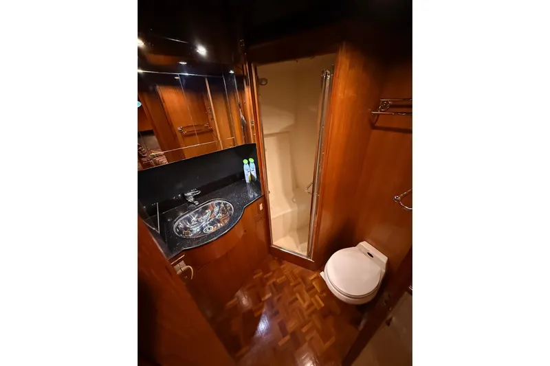 Bonnie Jean Yacht Photos Pics Luxurious bathroom in 1998 Ocean Alexander Pilothouse Model 584 yacht, featuring wood accents and modern fixtures.