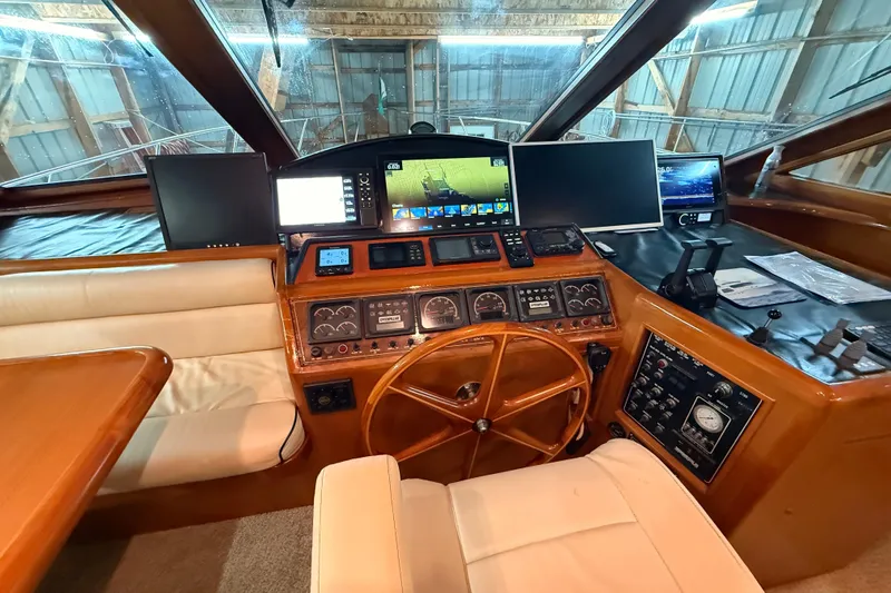 Bonnie Jean Yacht Photos Pics 1998 Ocean Alexander Pilothouse Model 584 helm with navigation screens and wooden steering wheel.