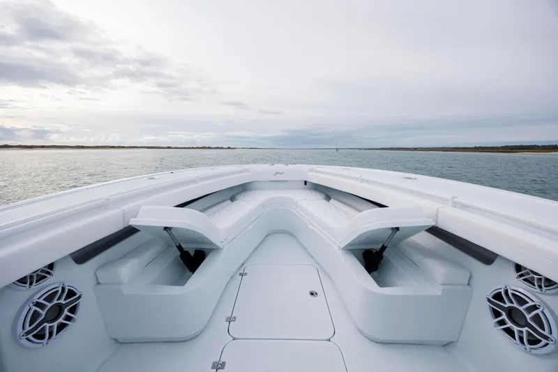  Yacht Photos Pics 2026 Yellowfin 36 Offshore boat interior with seating, on calm water under cloudy sky.