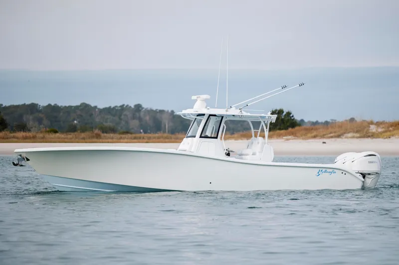  Yacht Photos Pics 2026 Yellowfin 36 Offshore boat on calm water near a sandy shore.