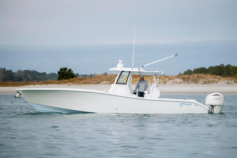  Yacht Photos Pics 2026 Yellowfin 36 Offshore boat on calm water near sandy shore.