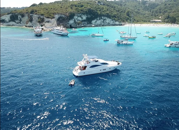  Yacht Photos Pics Majesty 66 Flybridge yacht on clear blue waters, surrounded by boats, 2010 model.