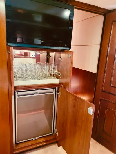  Yacht Photos Pics Majesty 66 Flybridge 2010 yacht interior with TV, glassware, and mini fridge.