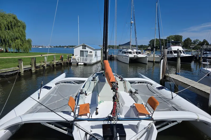 Crush Yacht Photos Pics 2022 Corsair 880 Sport trimaran docked at a marina with clear blue skies.