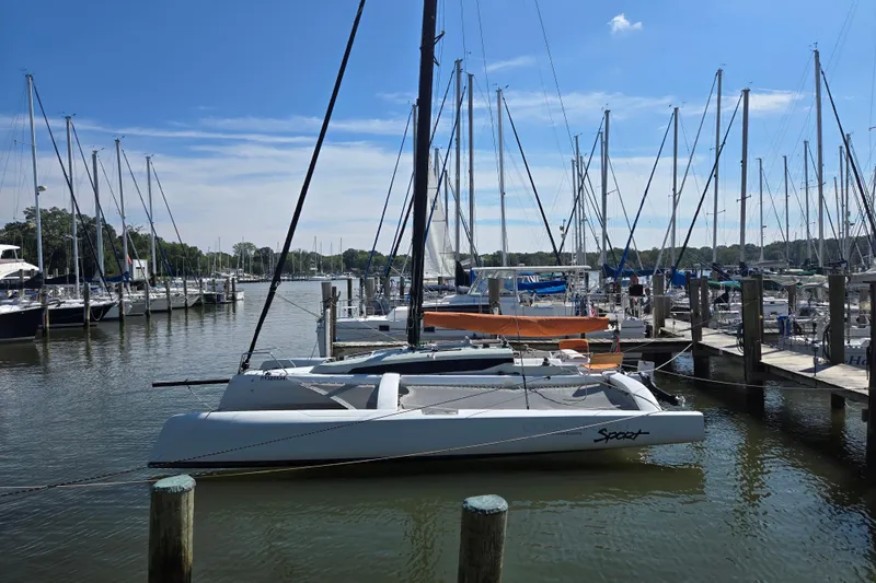 Crush Yacht Photos Pics Sailboats docked at a marina, featuring a 2022 Corsair 880 Sport trimaran.
