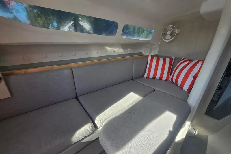 Crush Yacht Photos Pics Interior of 2022 Corsair 880 Sport boat with gray seating and striped pillows.