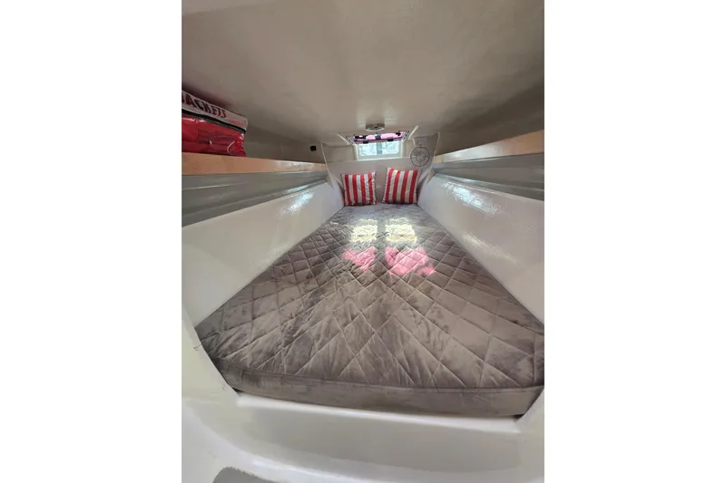 Crush Yacht Photos Pics Cozy interior cabin of 2022 Corsair 880 Sport with quilted bedding and striped pillows.