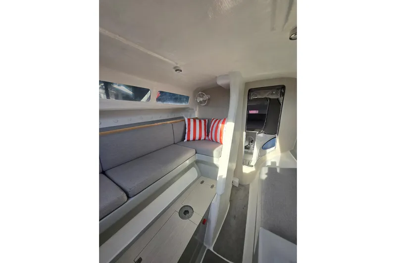 Crush Yacht Photos Pics Interior of 2022 Corsair 880 Sport sailboat with gray seating and striped cushions.