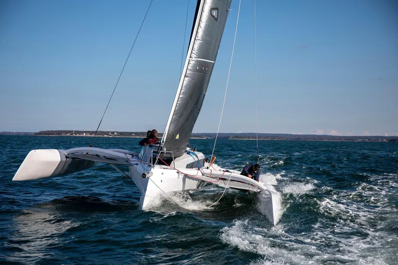 Crush Yacht Photos Pics 2022 Corsair 880 Sport sailing on open water under clear blue skies.