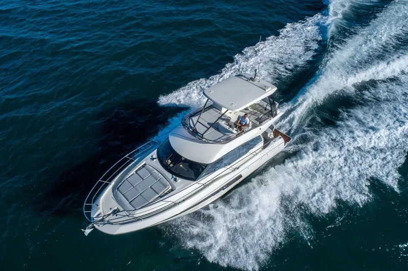  Yacht Photos Pics 2025 Prestige 460 Fly yacht cruising on open water, aerial view.
