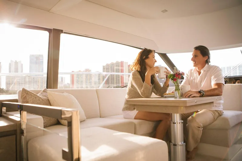  Yacht Photos Pics Couple enjoying coffee on a 2025 Prestige 460 Fly yacht, with city skyline view.