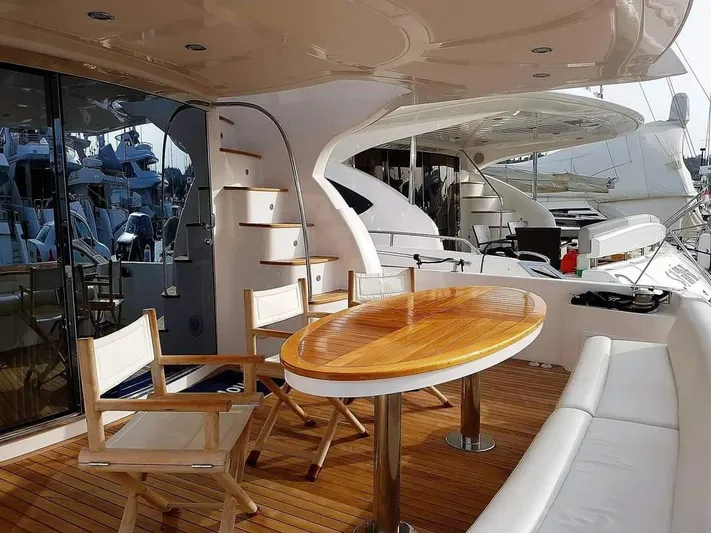  Yacht Photos Pics Luxurious 2010 Majesty 66 Flybridge yacht with elegant outdoor seating and wooden deck.