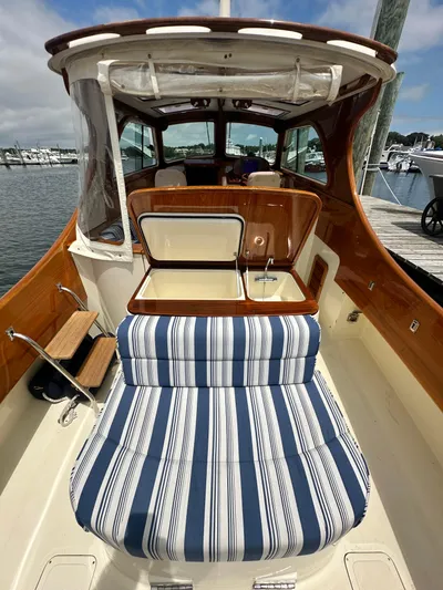  Yacht Photos Pics 2005 Hinckley 36 boat interior with striped seating and wooden accents at a marina.