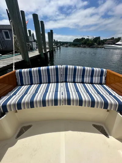  Yacht Photos Pics Hinckley 36 boat with striped seating, docked by a serene waterfront, 2005 model.
