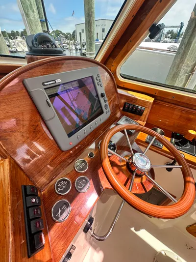  Yacht Photos Pics Helm of 2005 Hinckley 36 boat with wooden steering wheel and navigation system.