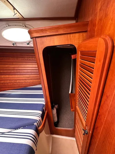  Yacht Photos Pics Interior of 2005 Hinckley 36 boat with wooden paneling and striped bedding.