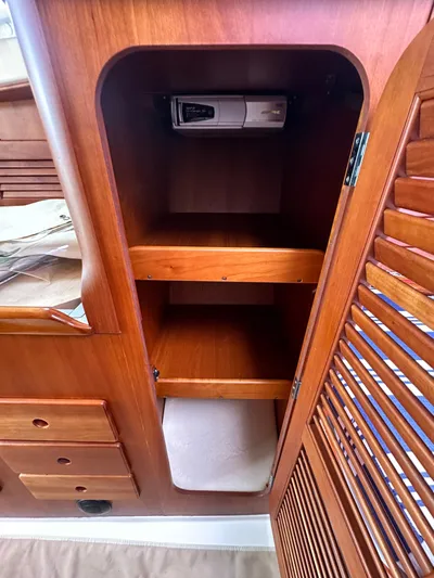  Yacht Photos Pics Wooden cabinet interior on a 2005 Hinckley 36 boat, featuring shelves and a small device.