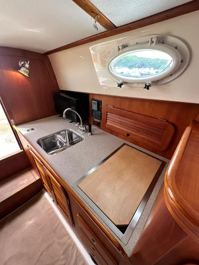  Yacht Photos Pics Hinckley 36 yacht interior kitchen with sink, countertop, and porthole window, 2005 model.