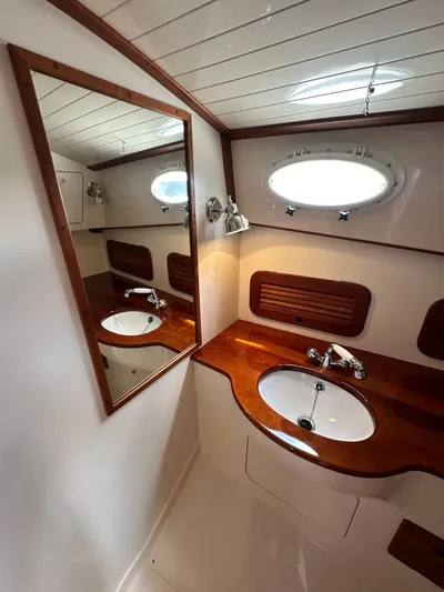  Yacht Photos Pics Luxurious 2005 Hinckley 36 yacht bathroom with wooden vanity and oval porthole window.
