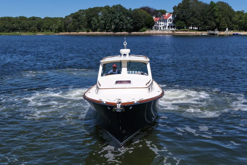  Yacht Photos Pics 2005 Hinckley 36 boat cruising on a serene lake with a scenic shoreline backdrop.