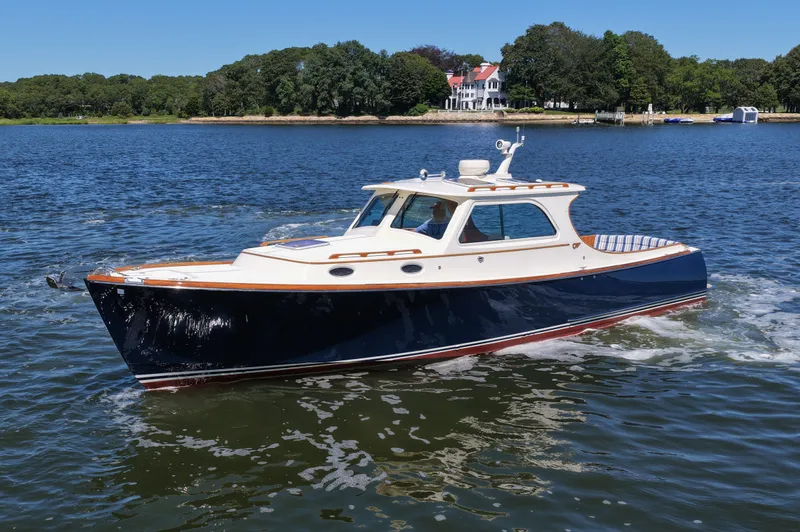 Yacht Photos Pics 2005 Hinckley 36 boat cruising on a scenic lake with a shoreline view.