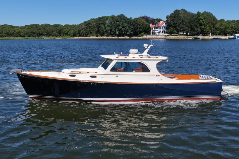  Yacht Photos Pics 2005 Hinckley 36 boat cruising on a serene lake with lush greenery.