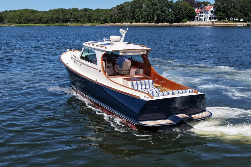  Yacht Photos Pics Hinckley 36 boat cruising on a lake, 2005 model, with scenic shoreline in background.