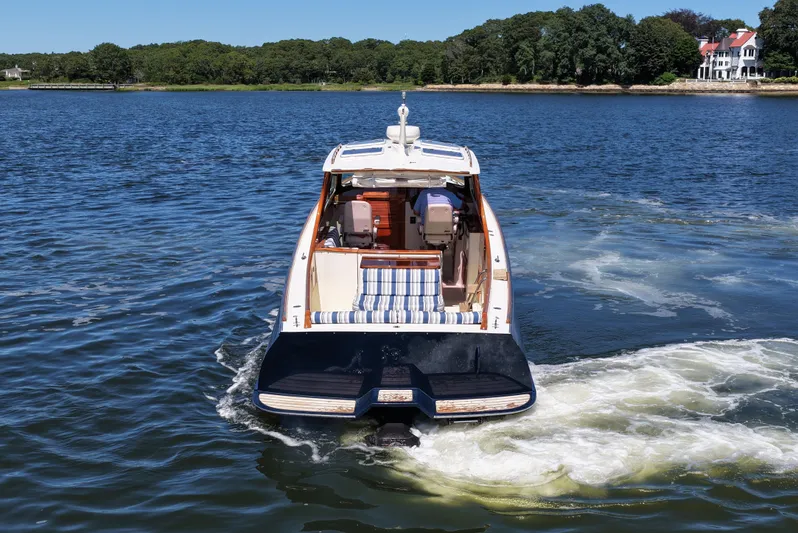  Yacht Photos Pics Hinckley 36 boat from 2005 cruising on a scenic lake with lush green shoreline.