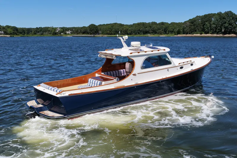  Yacht Photos Pics 2005 Hinckley 36 yacht cruising on a serene lake under a clear blue sky.