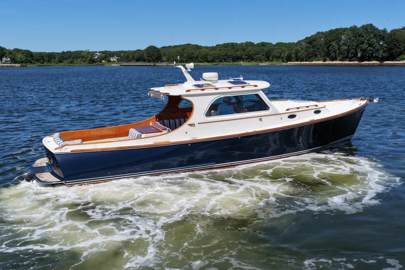  Yacht Photos Pics 2005 Hinckley 36 yacht cruising on a serene lake under a clear blue sky.