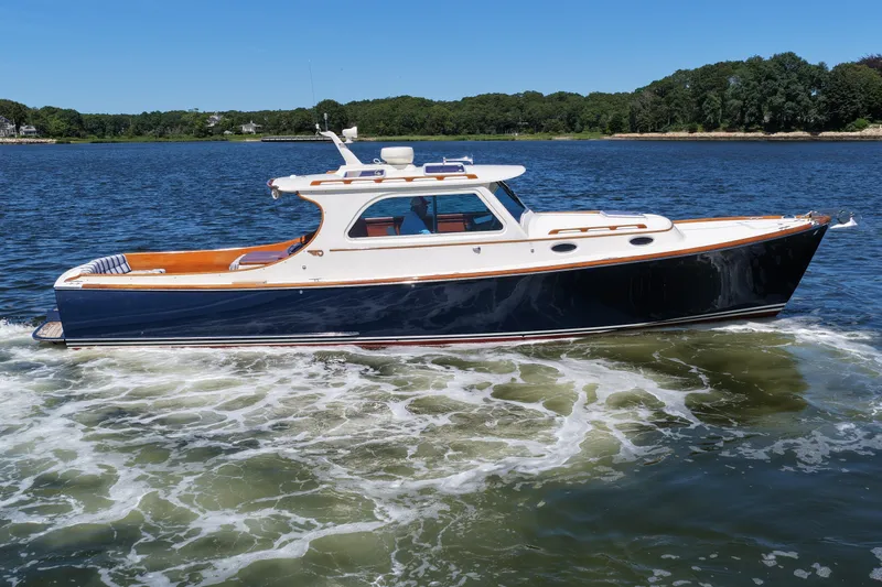  Yacht Photos Pics 2005 Hinckley 36 yacht cruising on a serene lake under a clear blue sky.
