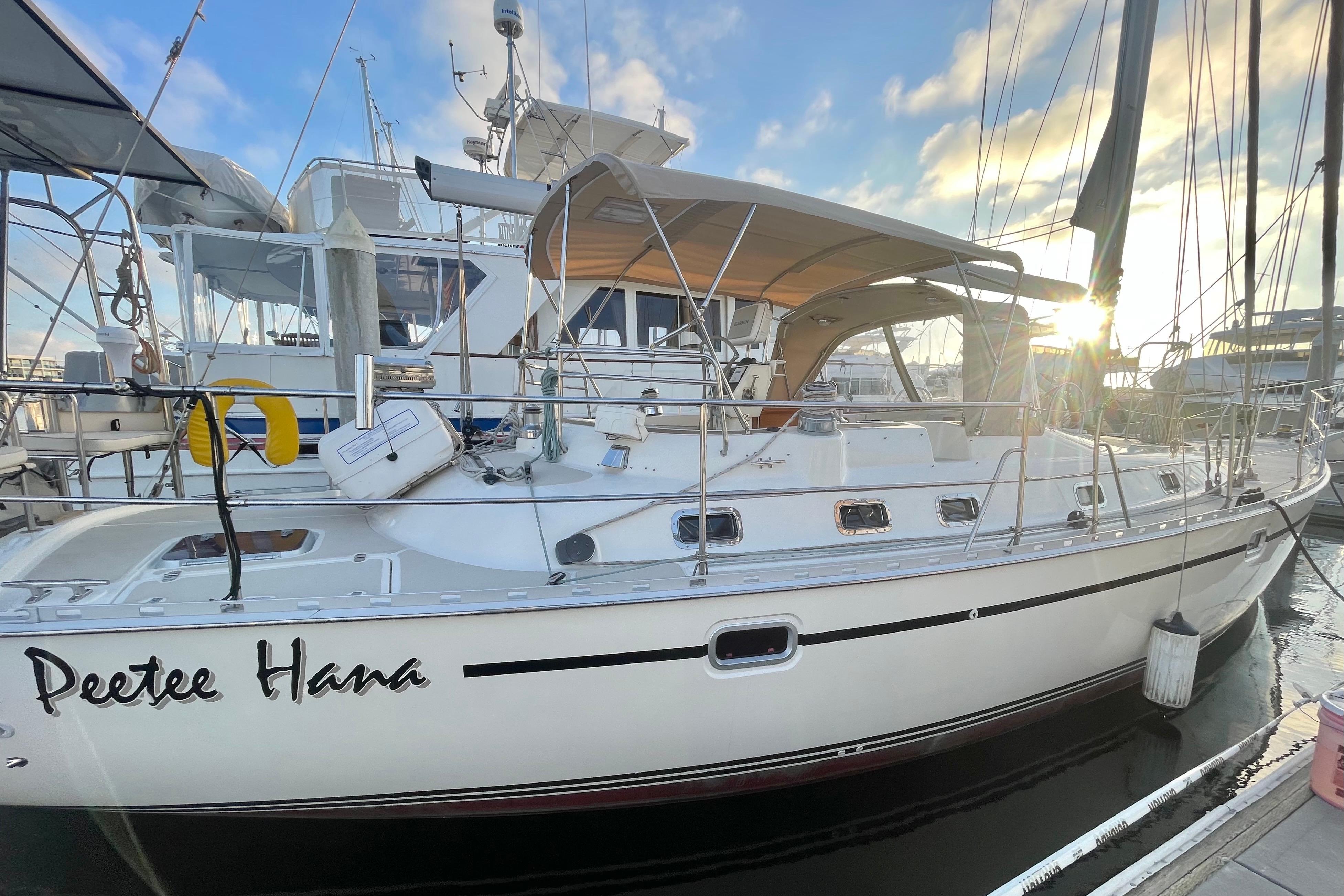 2008 Caliber 47 LRC sailboat docked at marina, sun setting in background.