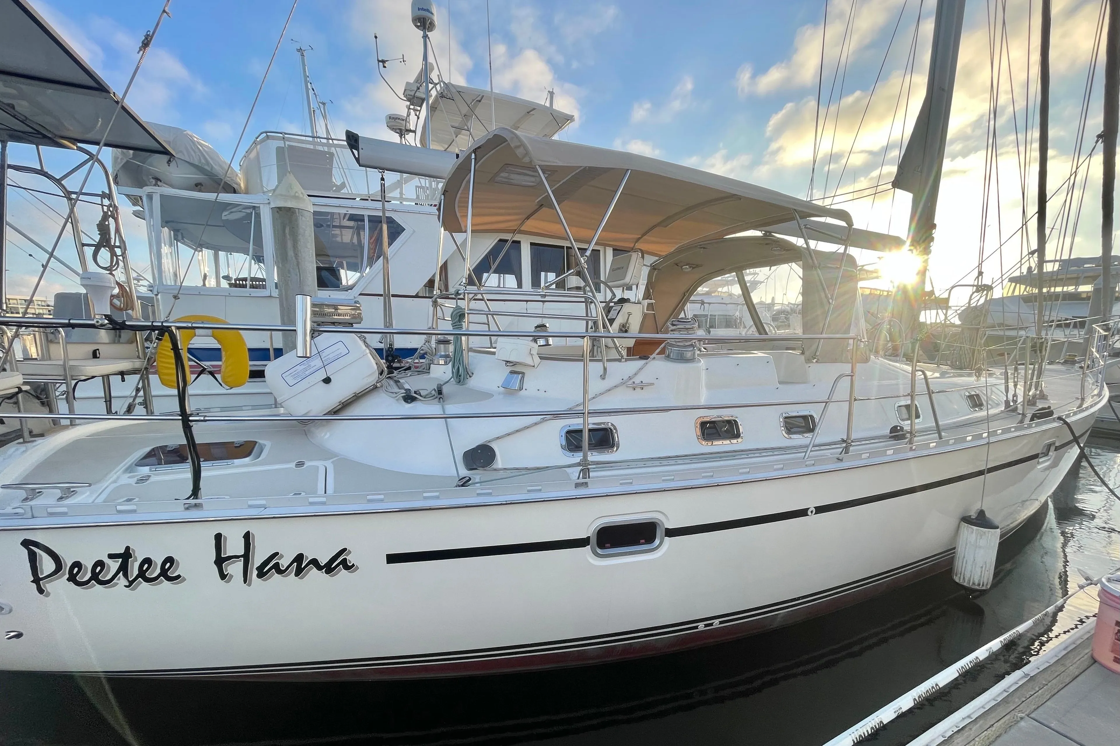 2008 Caliber 47 LRC sailboat docked at marina, sun setting in background.