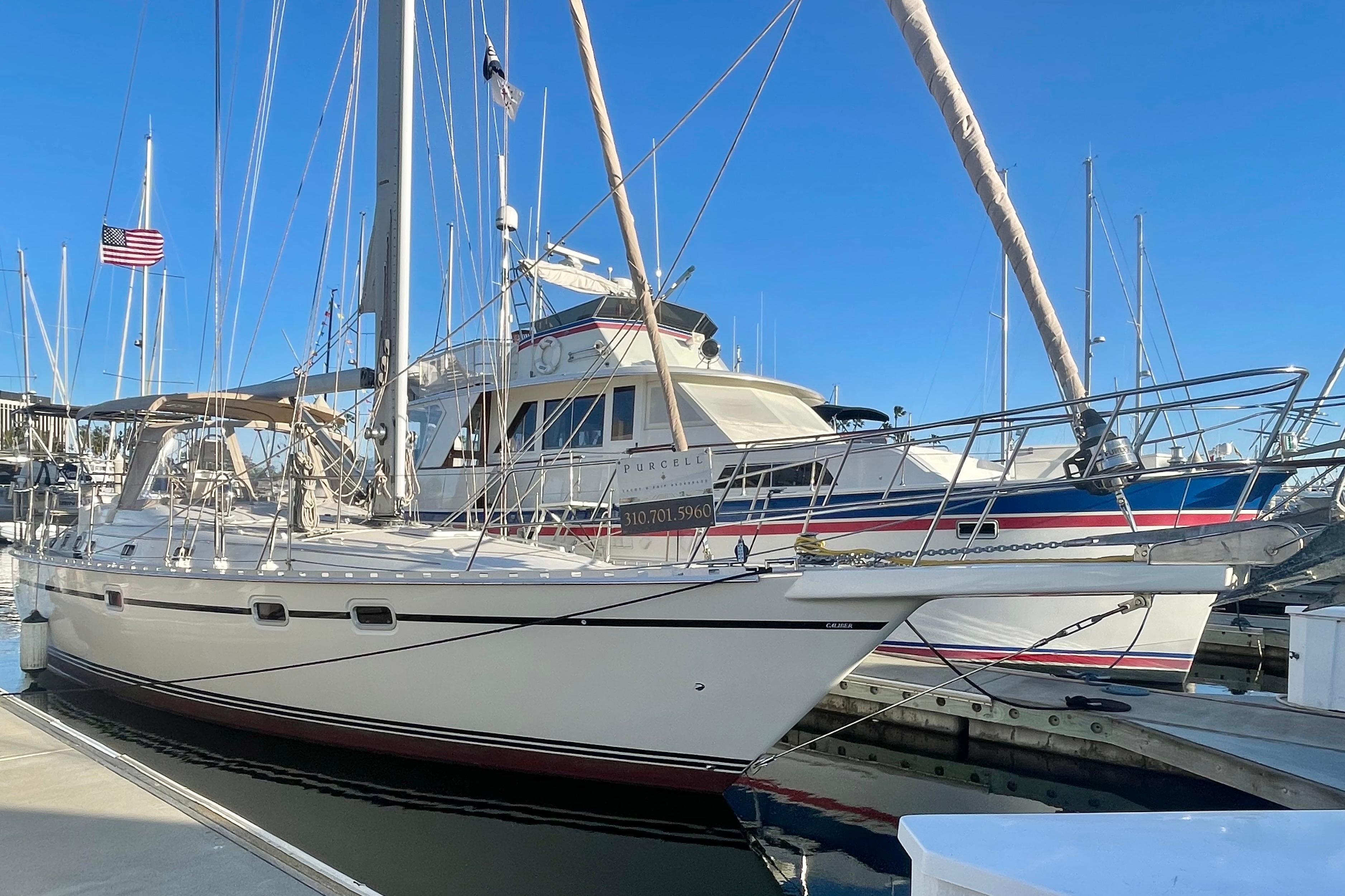 2008 Caliber 47 LRC sailboat docked at marina under clear blue sky.