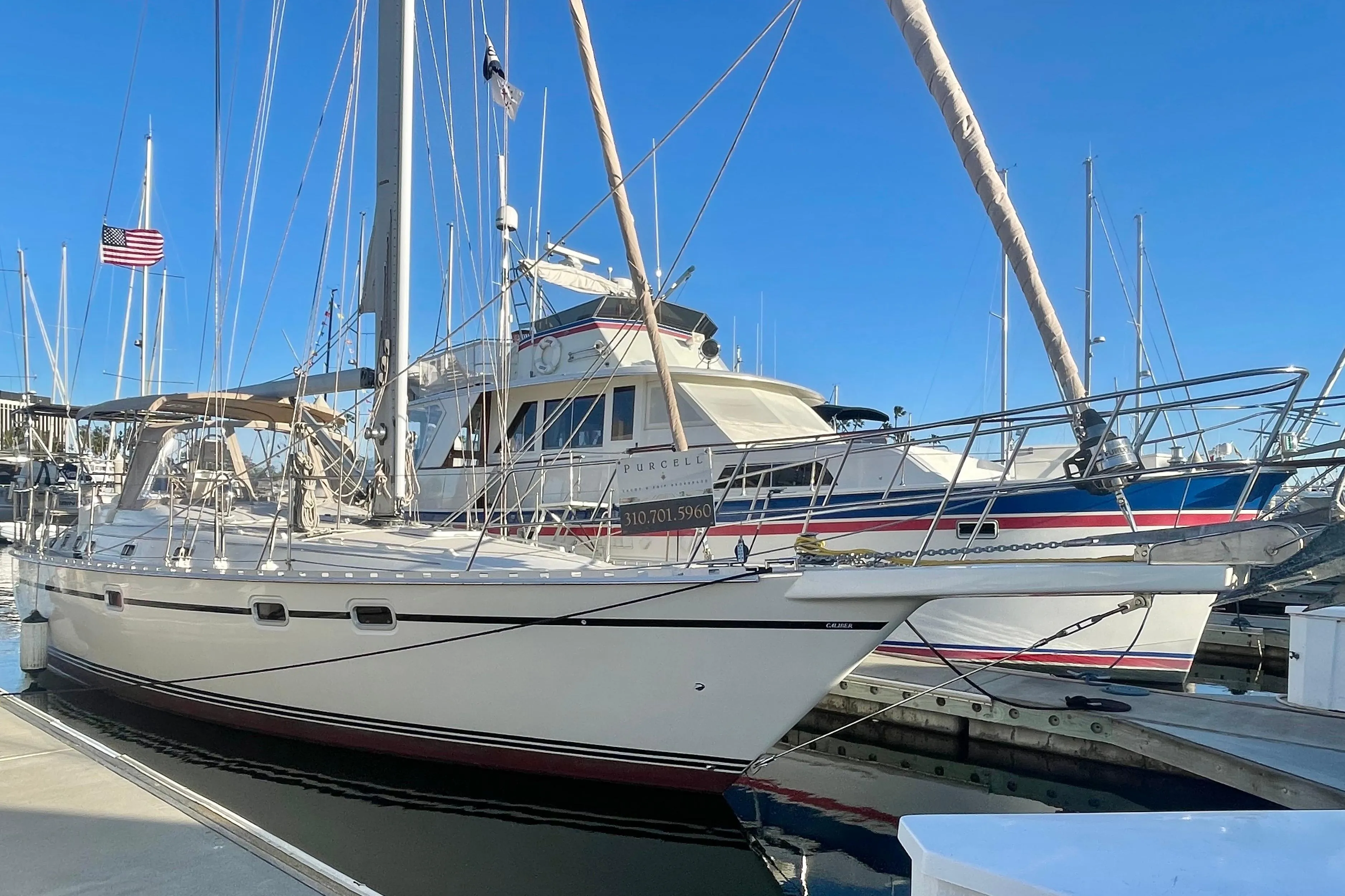 2008 Caliber 47 LRC sailboat docked at marina under clear blue sky.