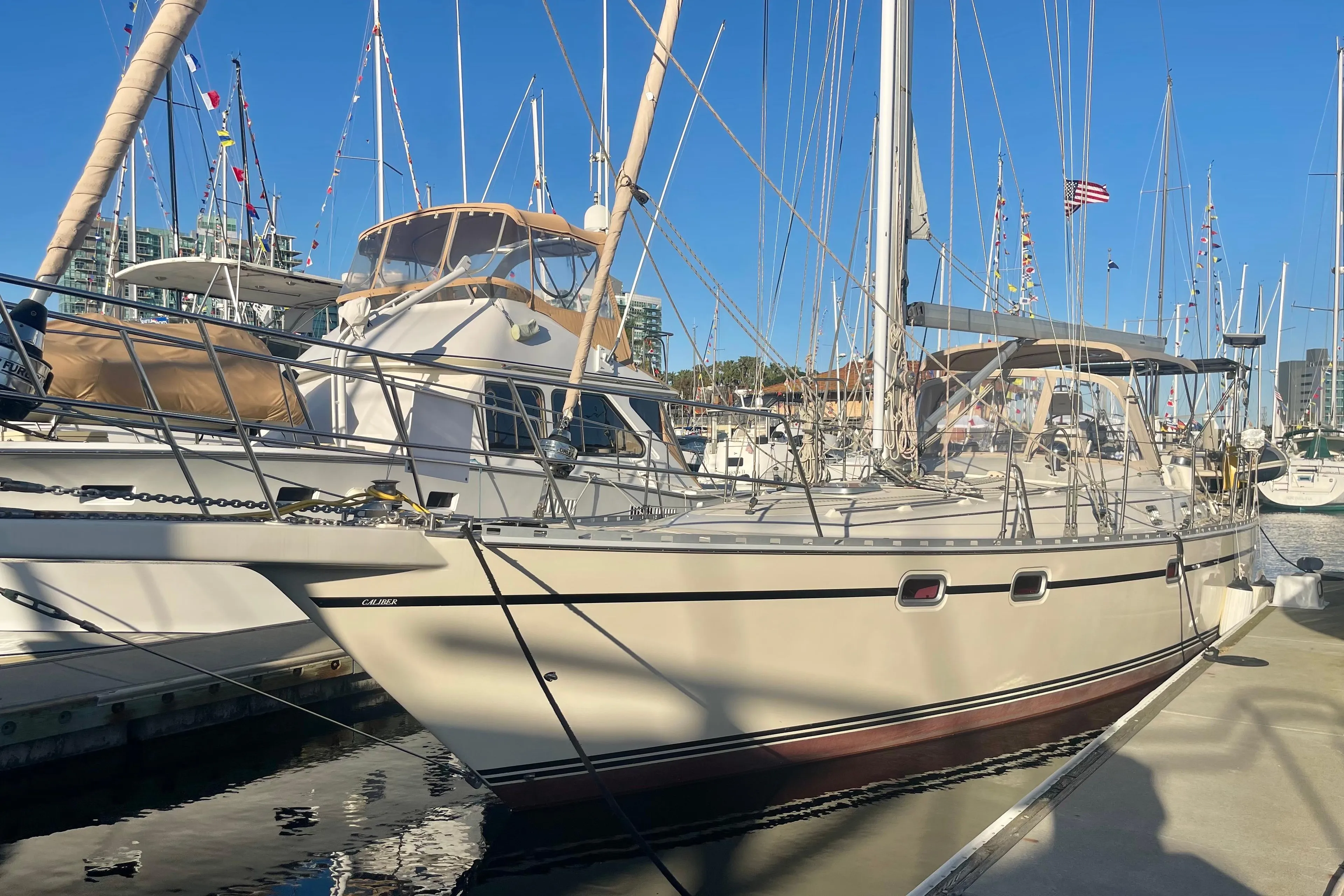 2008 Caliber 47 LRC sailboat docked at marina under clear blue sky.