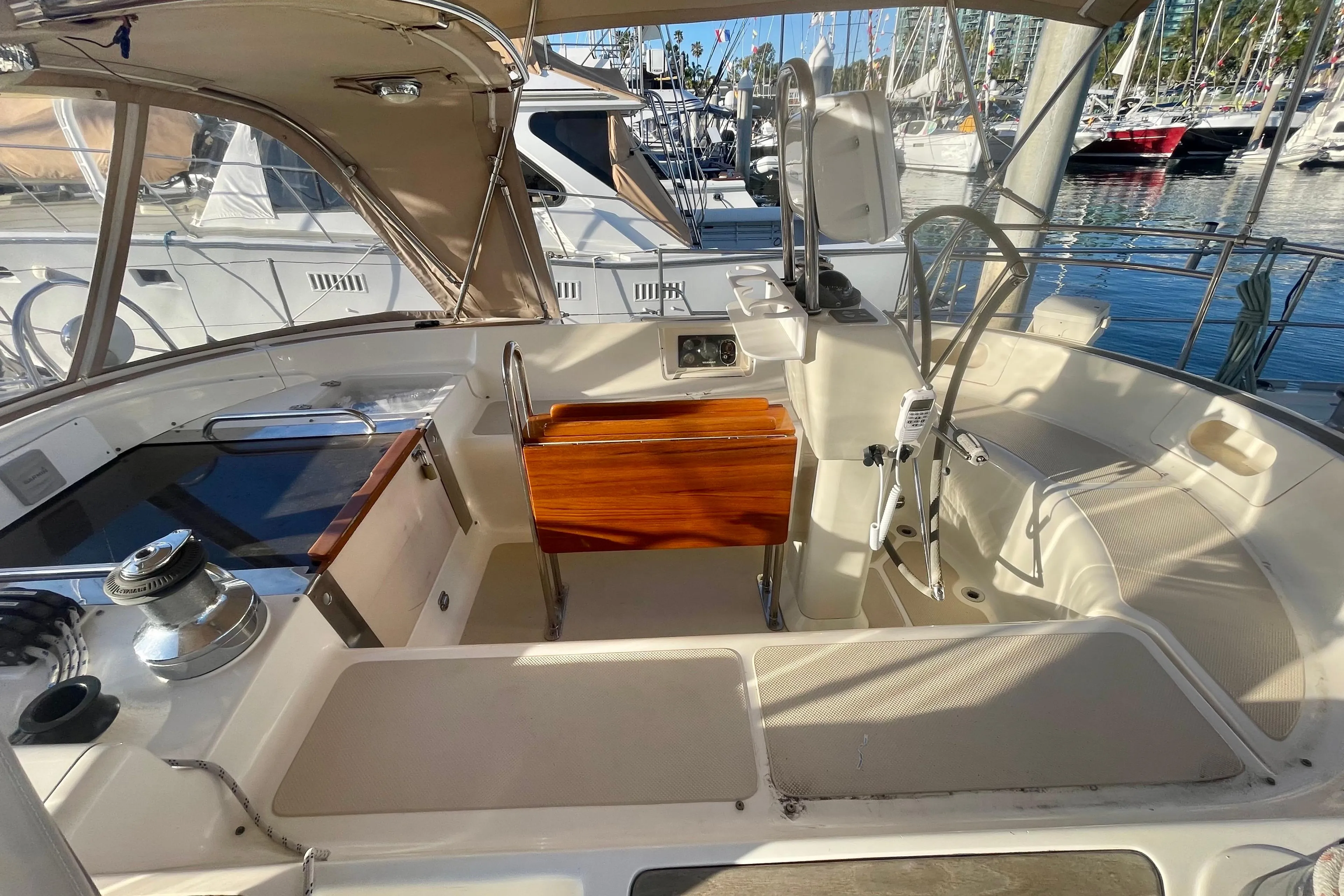 2008 Caliber 47 LRC yacht cockpit with seating, steering wheel, and wooden table in marina.