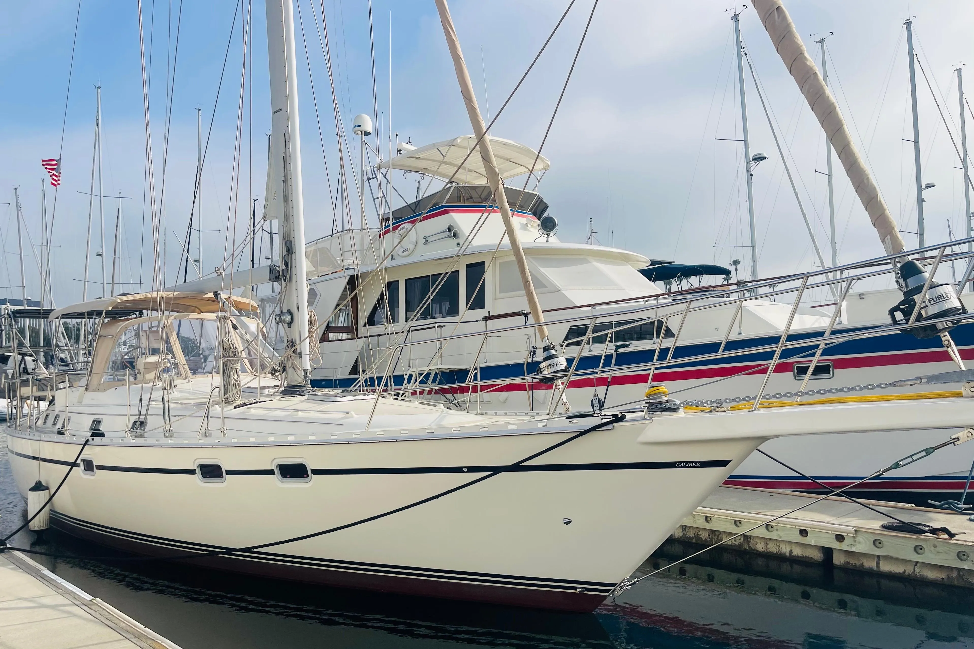 2008 Caliber center cockpit cutter yacht docked at marina, clear sky background.