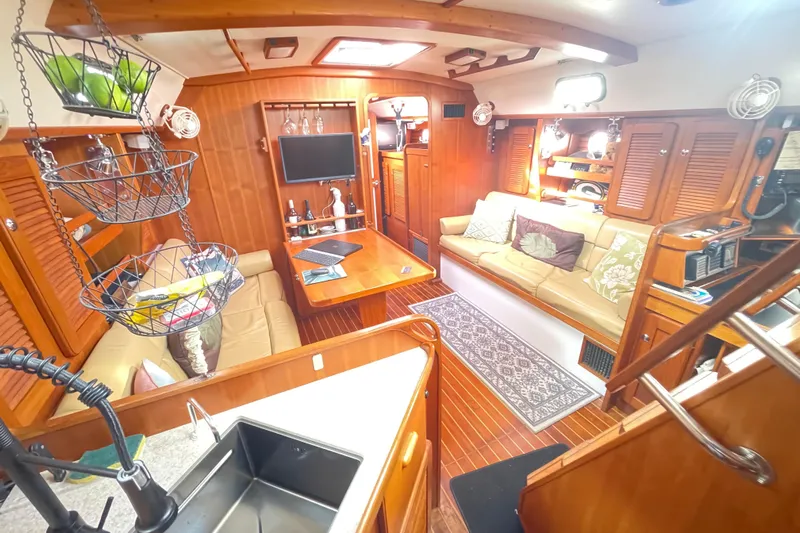 Peetee Hana Yacht Photos Pics Luxurious 2008 Caliber center cockpit cutter interior with wood finish and cozy seating area.