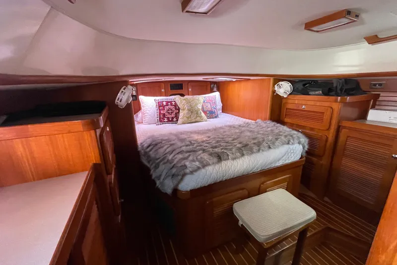 Peetee Hana Yacht Photos Pics Cozy cabin interior of 2008 Caliber center cockpit cutter with plush bedding and wooden furnishings.