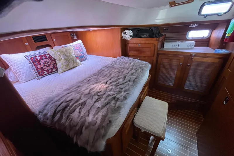 Peetee Hana Yacht Photos Pics Cozy cabin interior of 2008 Caliber center cockpit cutter with plush bedding and wooden cabinetry.