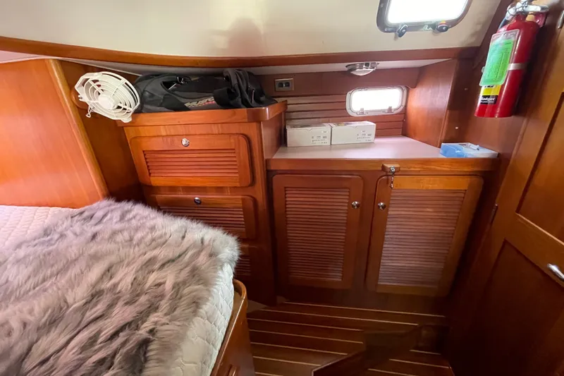 Peetee Hana Yacht Photos Pics Cozy cabin interior of 2008 Caliber center cockpit cutter with wooden cabinetry and bedding.