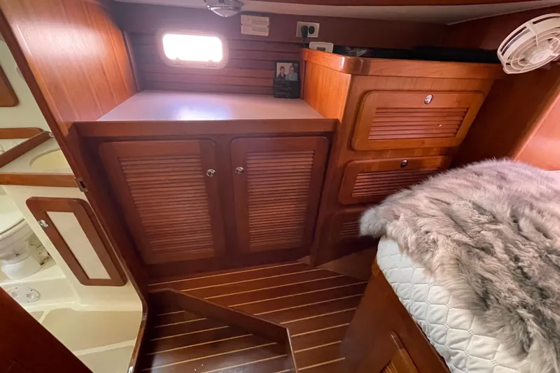 Peetee Hana Yacht Photos Pics Interior of 2008 Caliber center cockpit cutter with wooden cabinetry and cozy bedding.