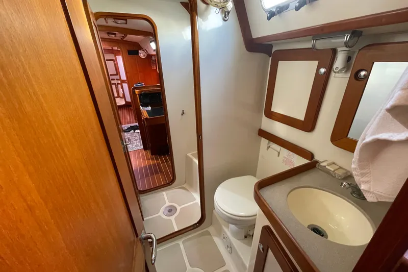 Peetee Hana Yacht Photos Pics 2008 Caliber center cockpit cutter bathroom with sink, toilet, and wooden accents.