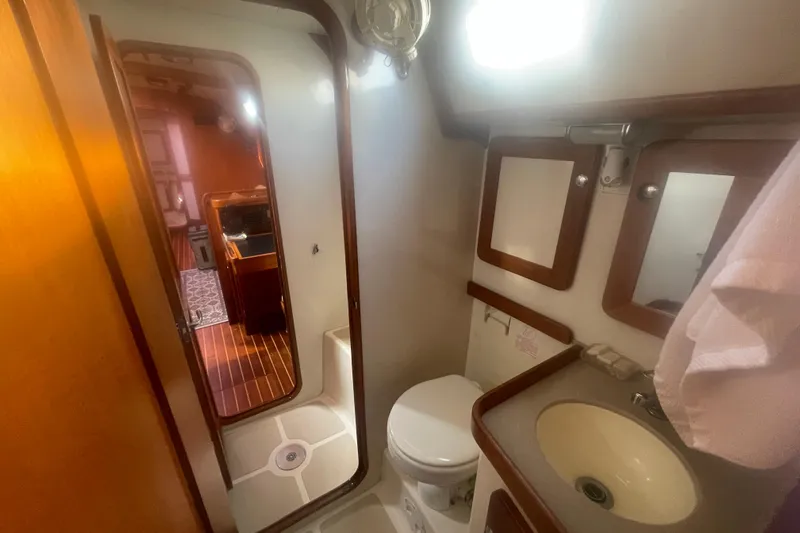 Peetee Hana Yacht Photos Pics 2008 Caliber center cockpit cutter bathroom with sink, toilet, and wooden accents.